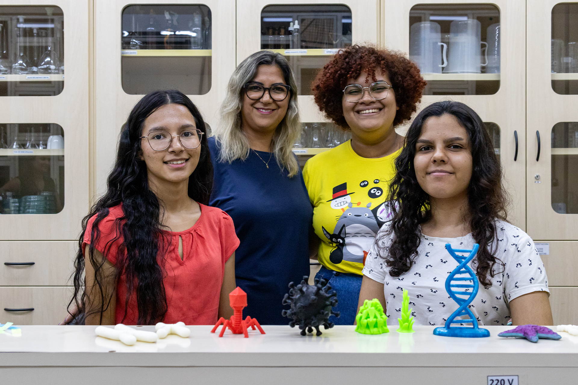 Professora Ana Clara Barbosa, as estudantes do técnico integrado em Instrumento Musical, Millena de Morais e Emilly Letícia Lima, e mais a aluna de Engenharia de Controle e Automação, Júlia Vieira Pontes, exibem os materiais didáticos produzidos a partir do projeto de ensino.